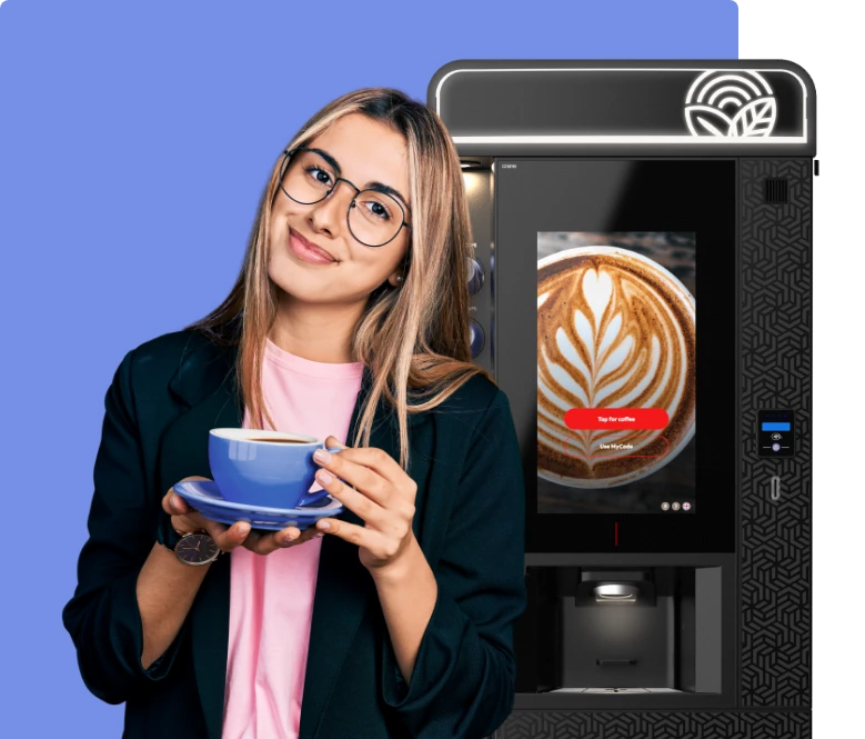 Lady with a cup of coffee on front of a coffee vending machine